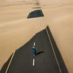femme qui marche sur une route dans le désert